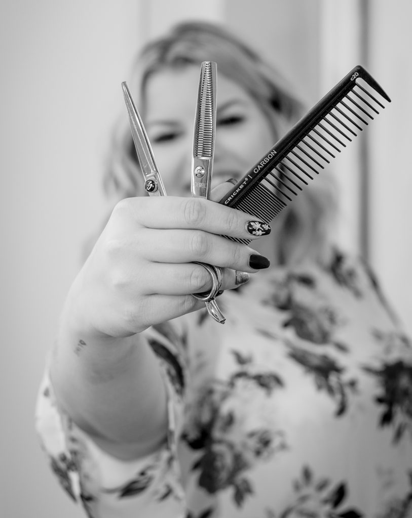 Kayla with scissors and comb in her salon